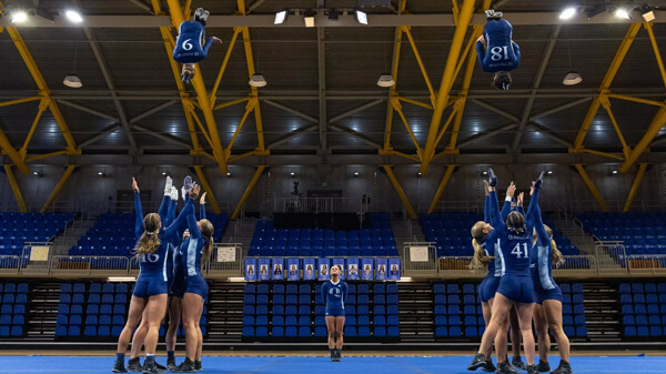 Acrobatics and tumbling team members throw two teammates in the air during a routine