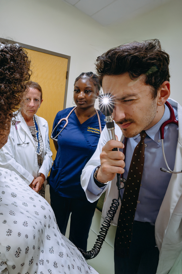 A student in the graduate nurse practitioner program performs an exam on a patient in the simulation lab