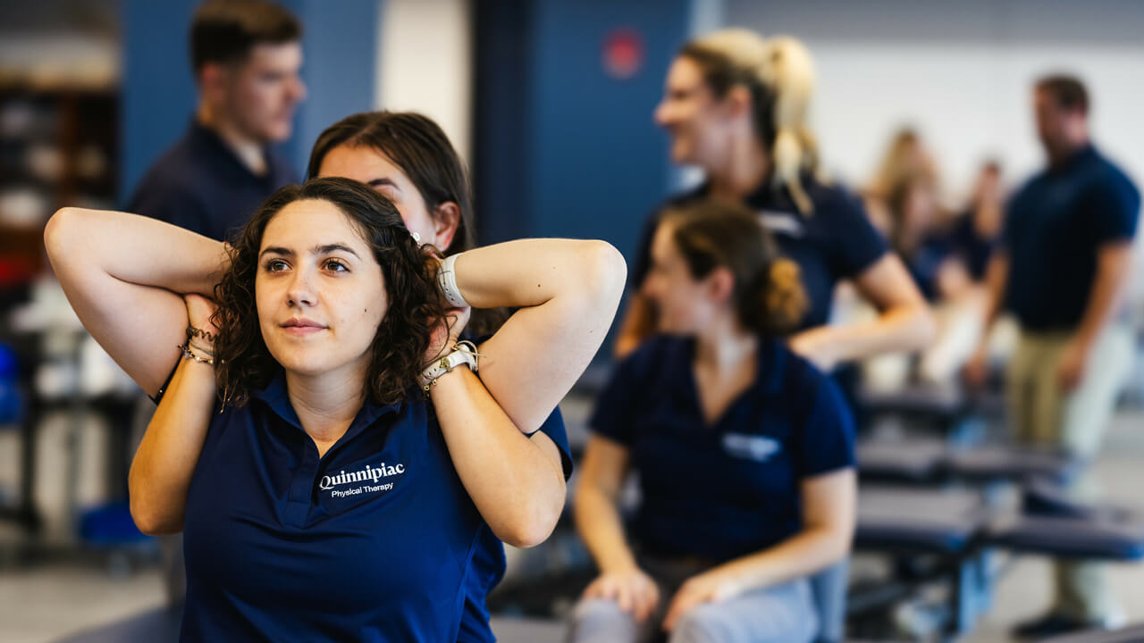 Physical therapy students perform a chiropractic exercise on each other.