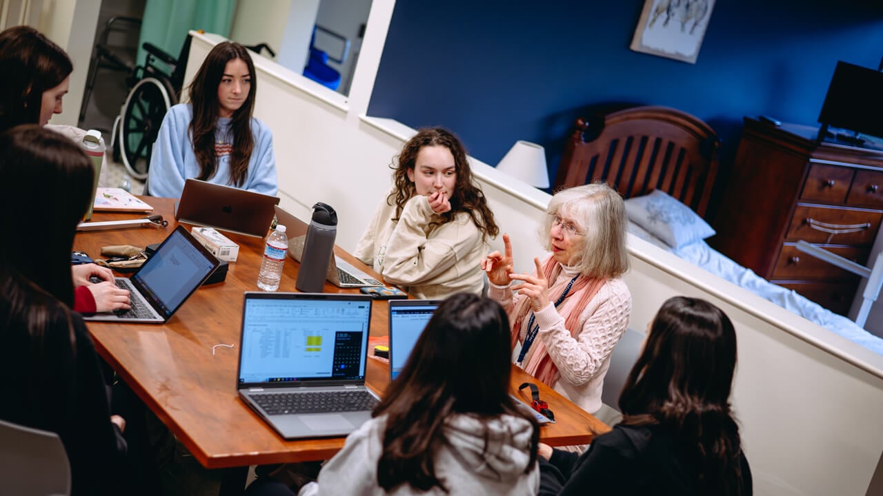 A professor instructs a class of occupational therapists in the simulation suite.