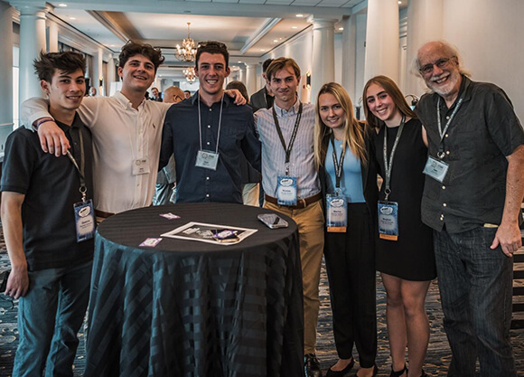 A group stands shoulder to shoulder and smiles