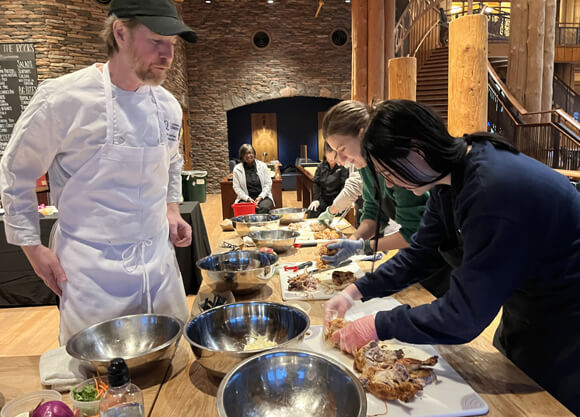 Students using a chicken to make dishes