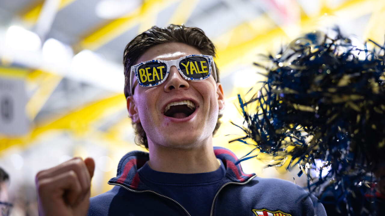 Individual wearing glasses that say "Beat Yale"