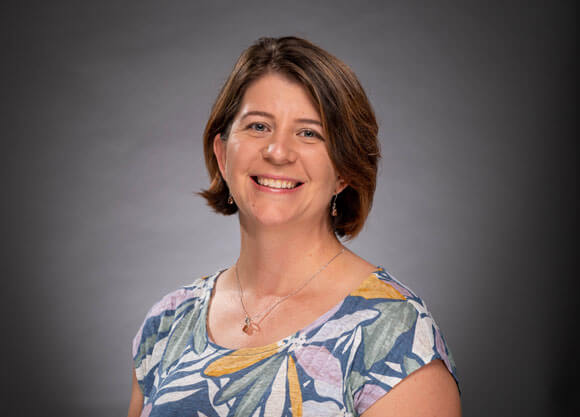 Dr. Shawna Reed smiling against a grey background