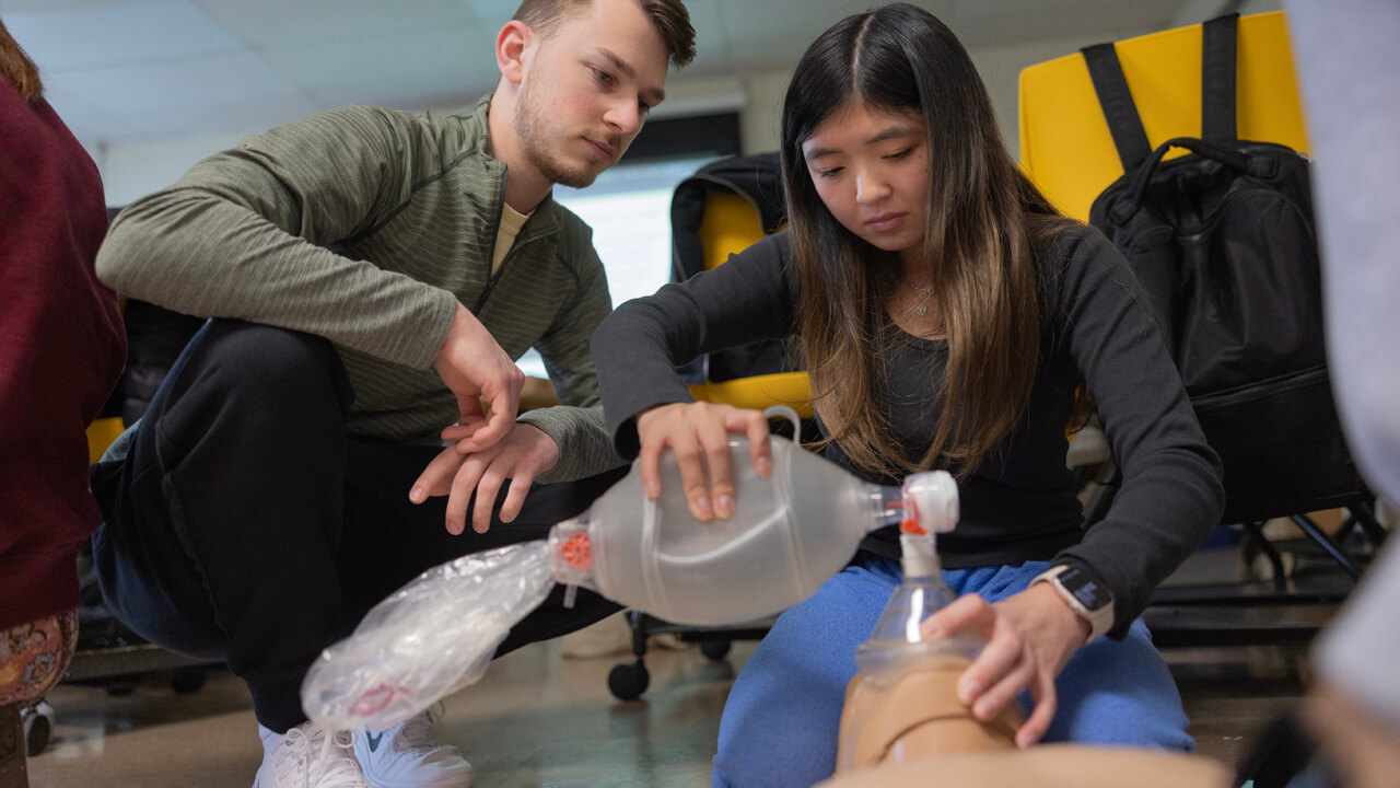 Students learn CPR practices in a living learning community event.