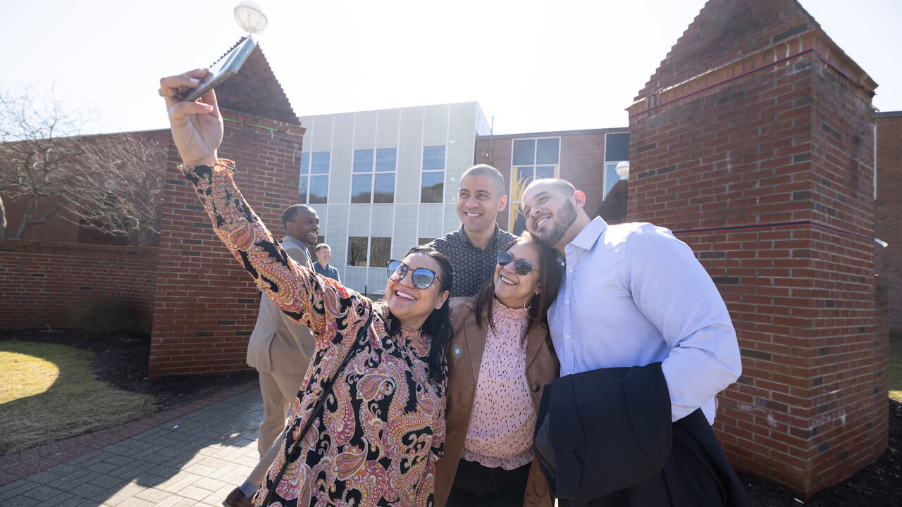 A family takes a selfie outside in the bright sunshine