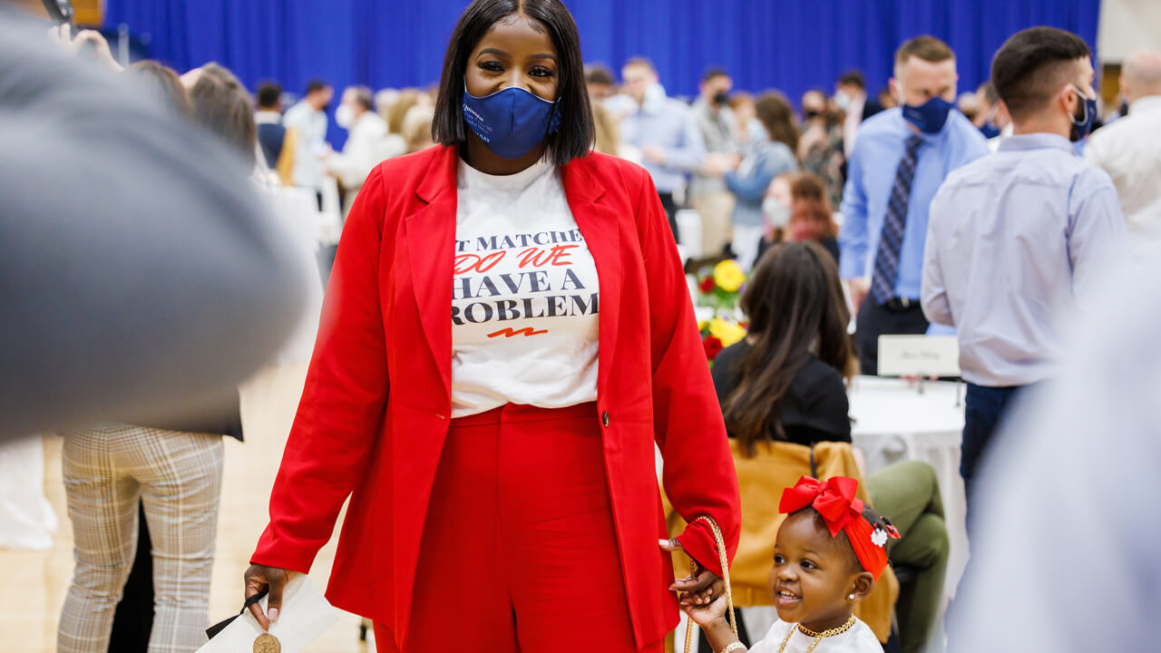 Caurice Wynter holds her Match envelope in one hand and her daughter's hand in the other