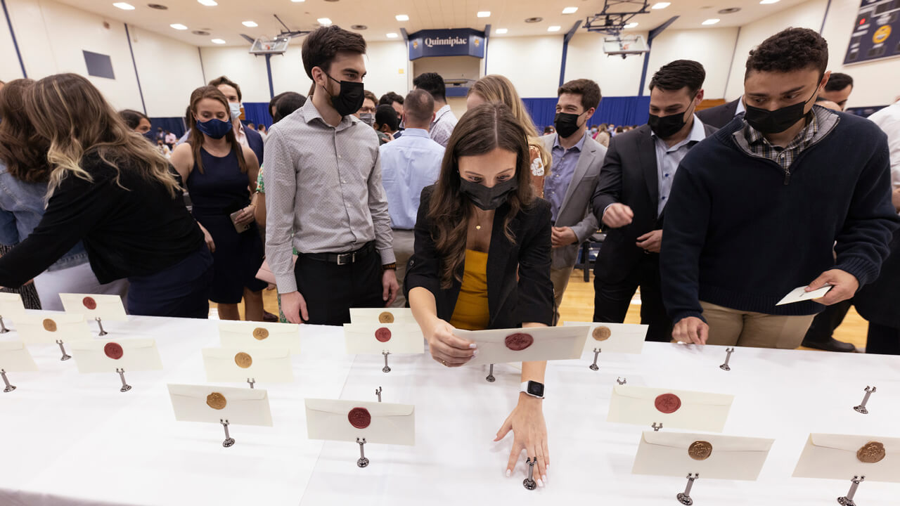 Students look for their envelope with their residency match during Match Day