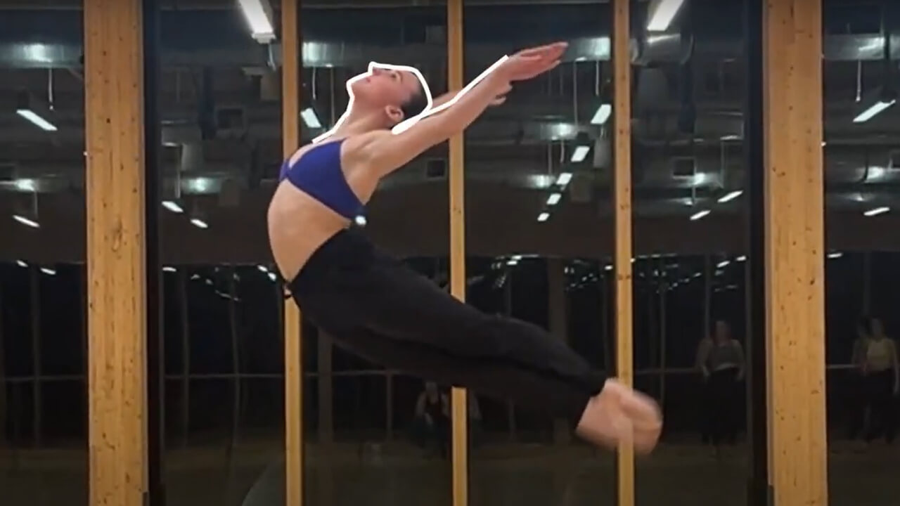 A photo of a dancer in the middle of a jump, plays video