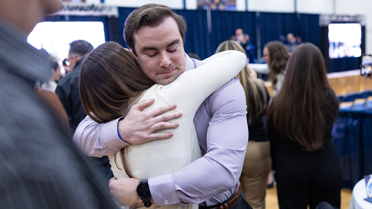 Zak Foster closes his eyes as he receives a hug from a loved one