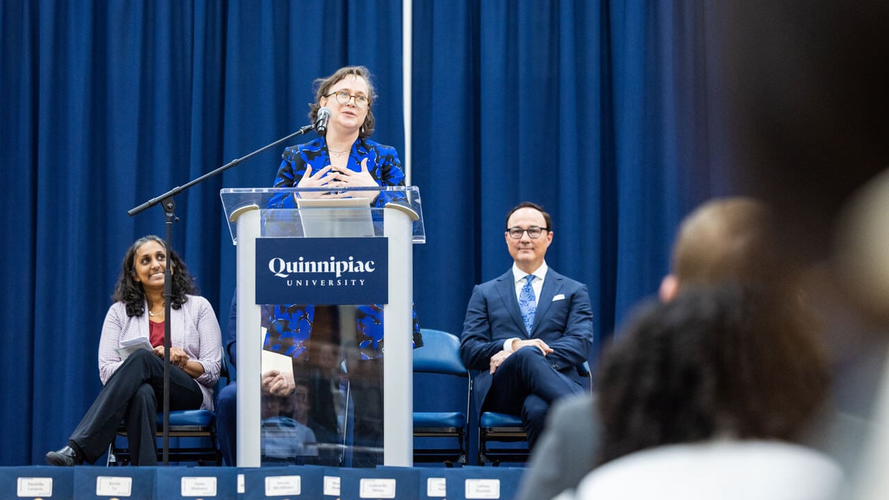 School of Medicine administrator speaks at the podium to a crowd