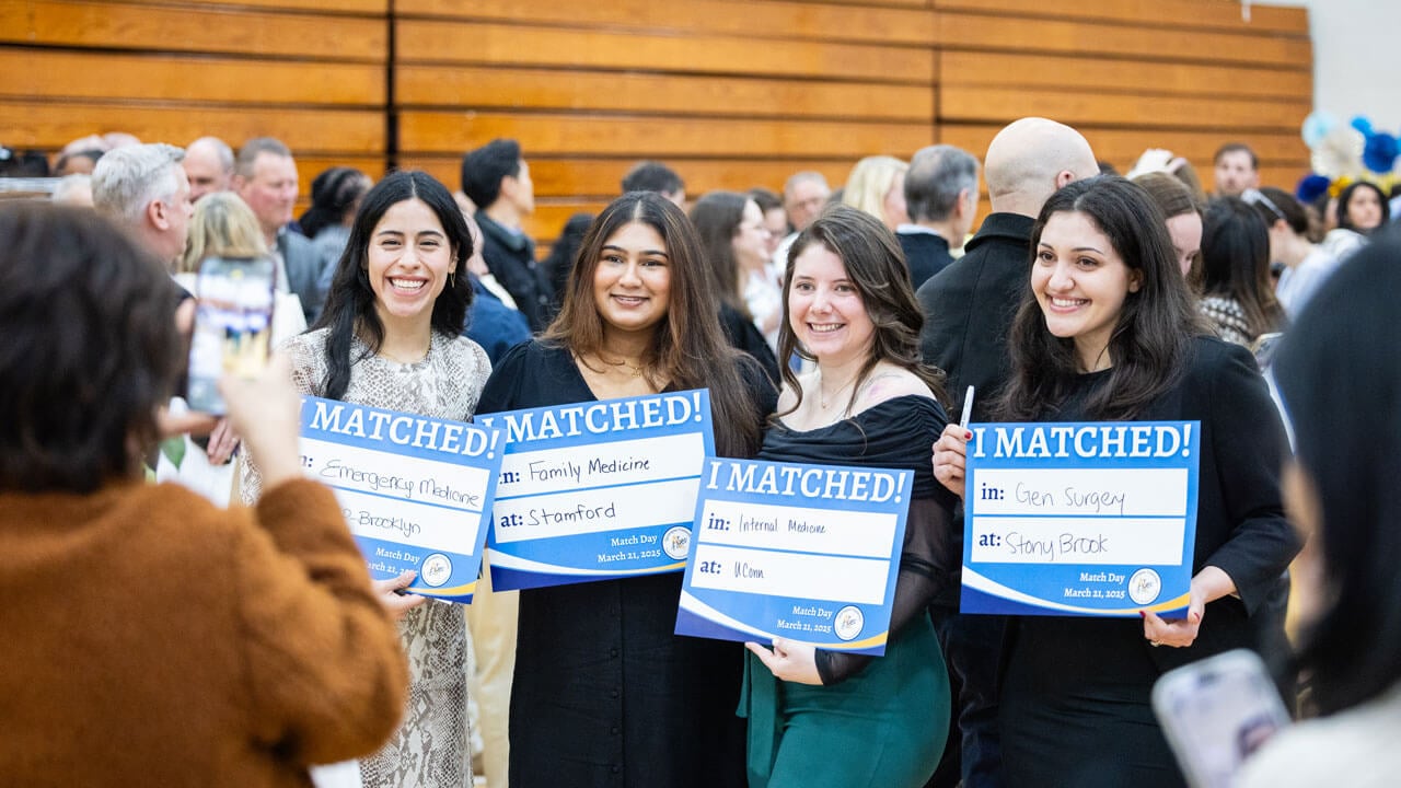 Four School of Medicine students smile as they hold an 'I Matched!' sign