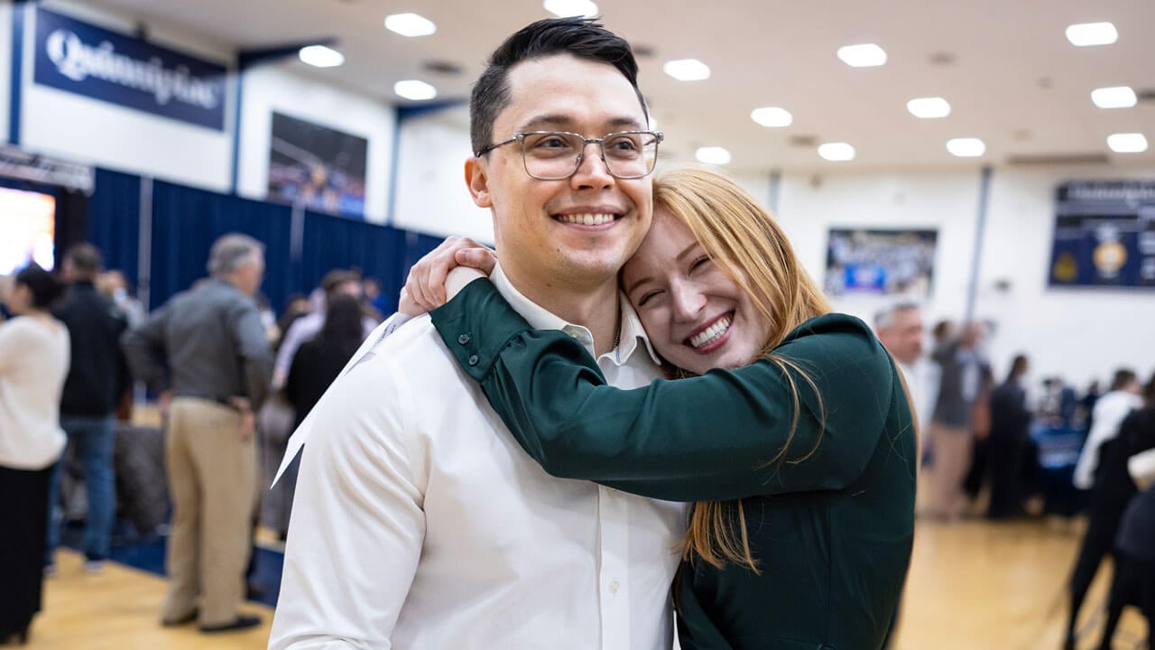 Two students smile as they hug each other at Match Day 2025