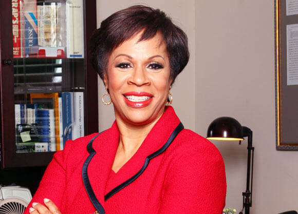 ck hoffler standing in office in red suit