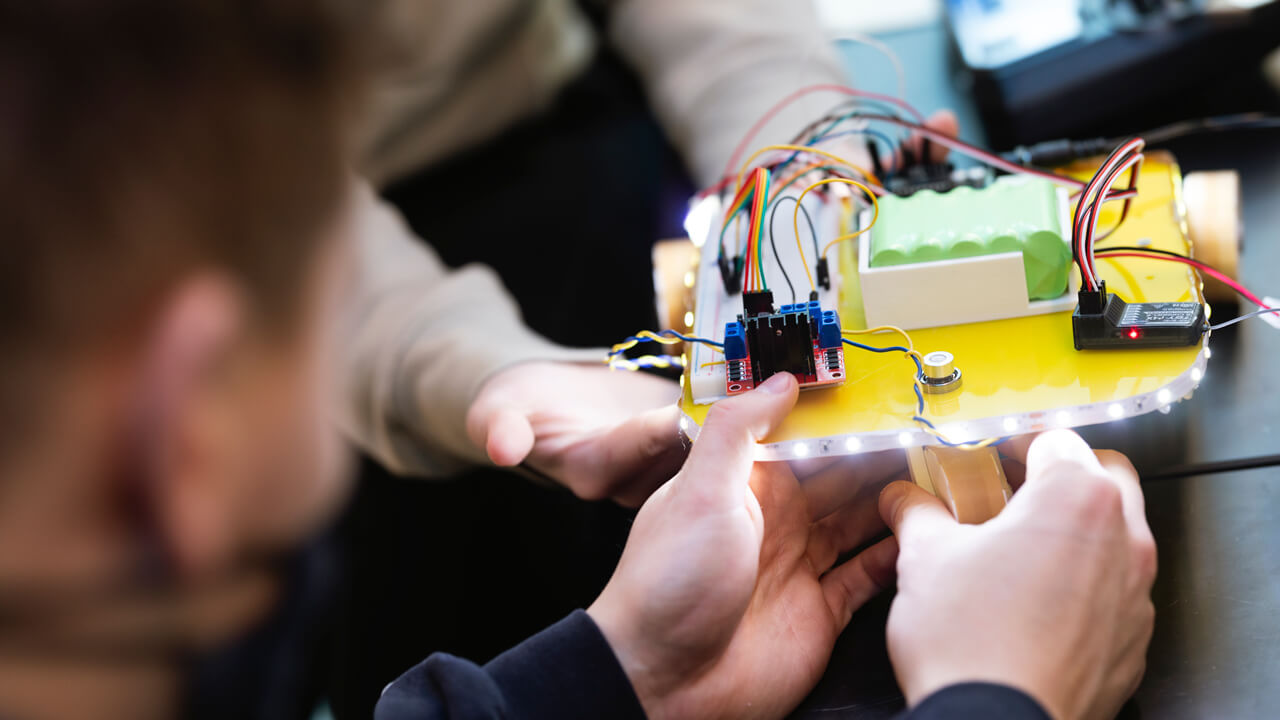 Students building a small robot in the Maker Space Innovation Hub in the School of Computing and Engineering.