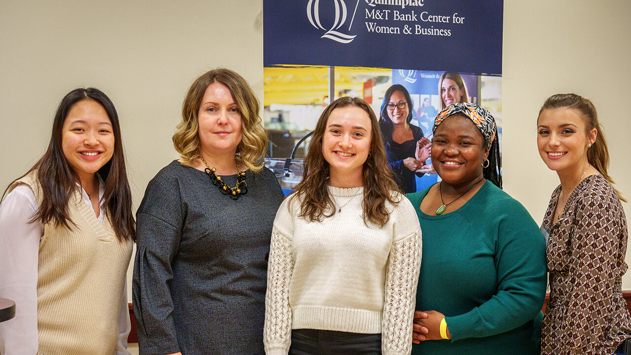 Five women smiling in front of M&T Bank sign