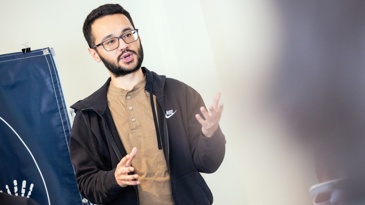 A student talking with his hands, giving a presentation.
