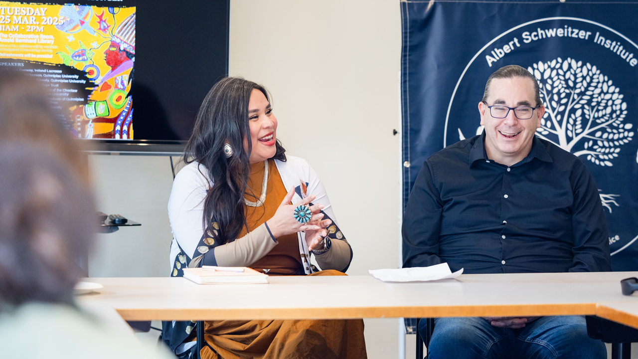 A woman leads a discussion with fellow visitors and students at the Albert Schweitzer Institute.