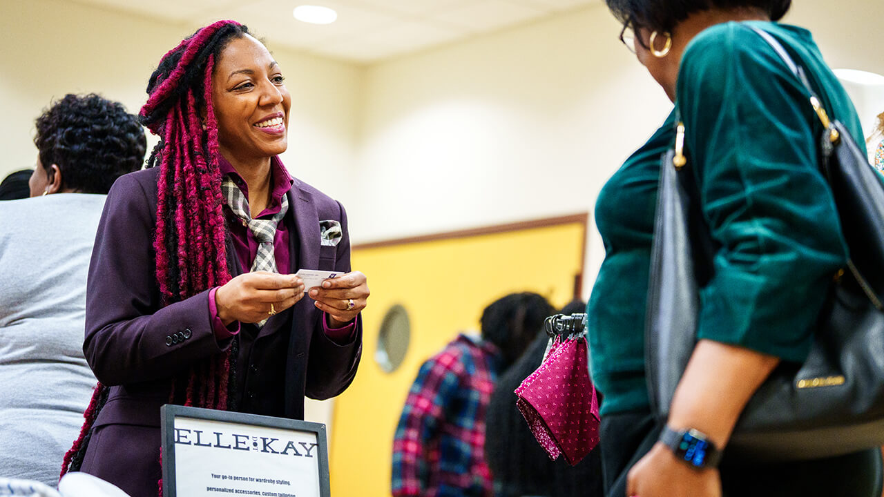 Woman hands out business cards for her company