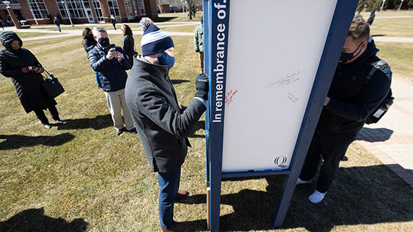 Students, staff and faculty writes messages of hope on message boards outside on the Mount Carmel Campus quad