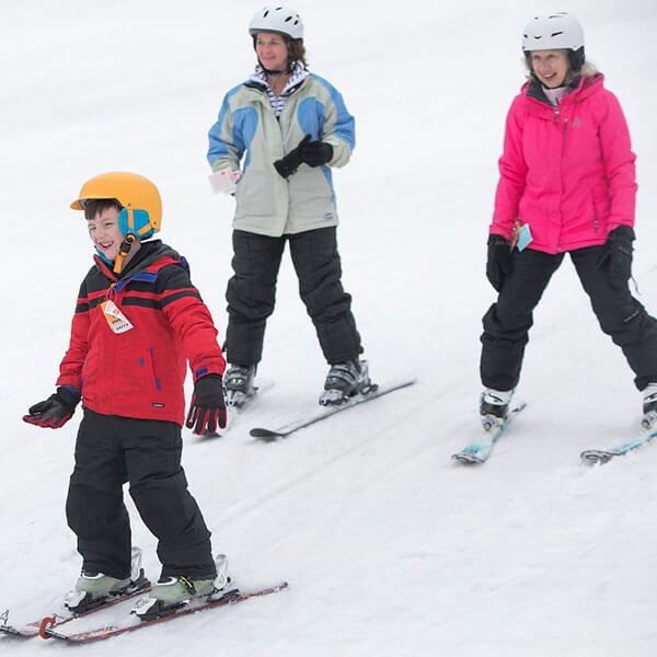 2 adults and a child skiing.