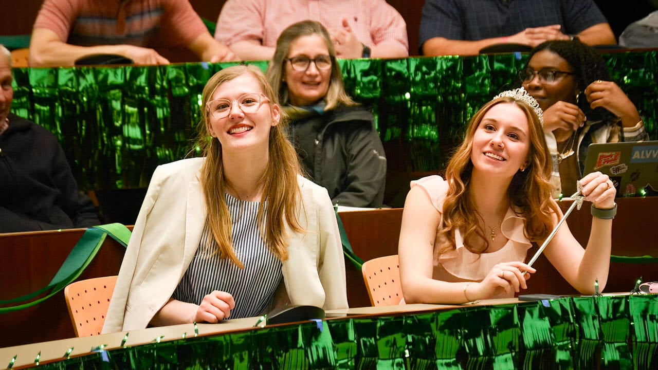 Audience members smile in their costumes at PILP auction.