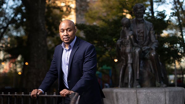 Don Sawyer in a Harlem neighborhood with the sun shining behind him