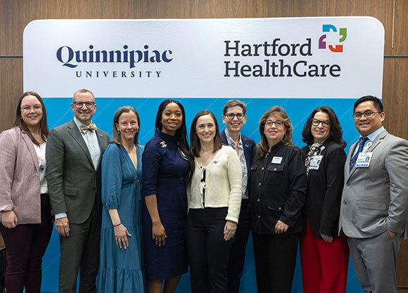Administrators stand and smile for a photo.