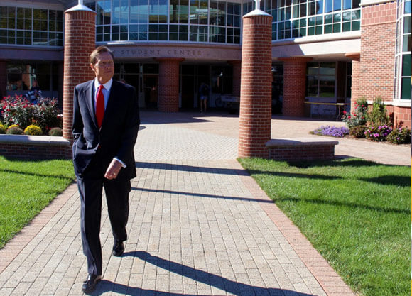 President John L. Lahey walking on a campus sidewalk