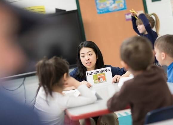 Monroe shares a book with students.