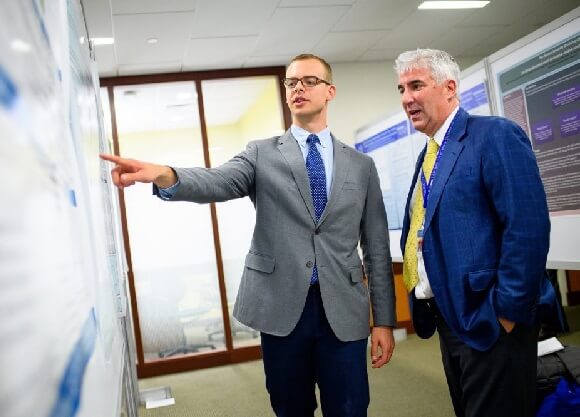 Dembowski points to his poster.