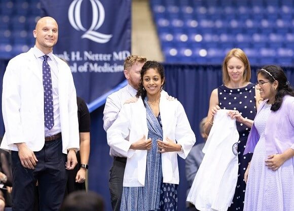 Faculty cloak students in white coats