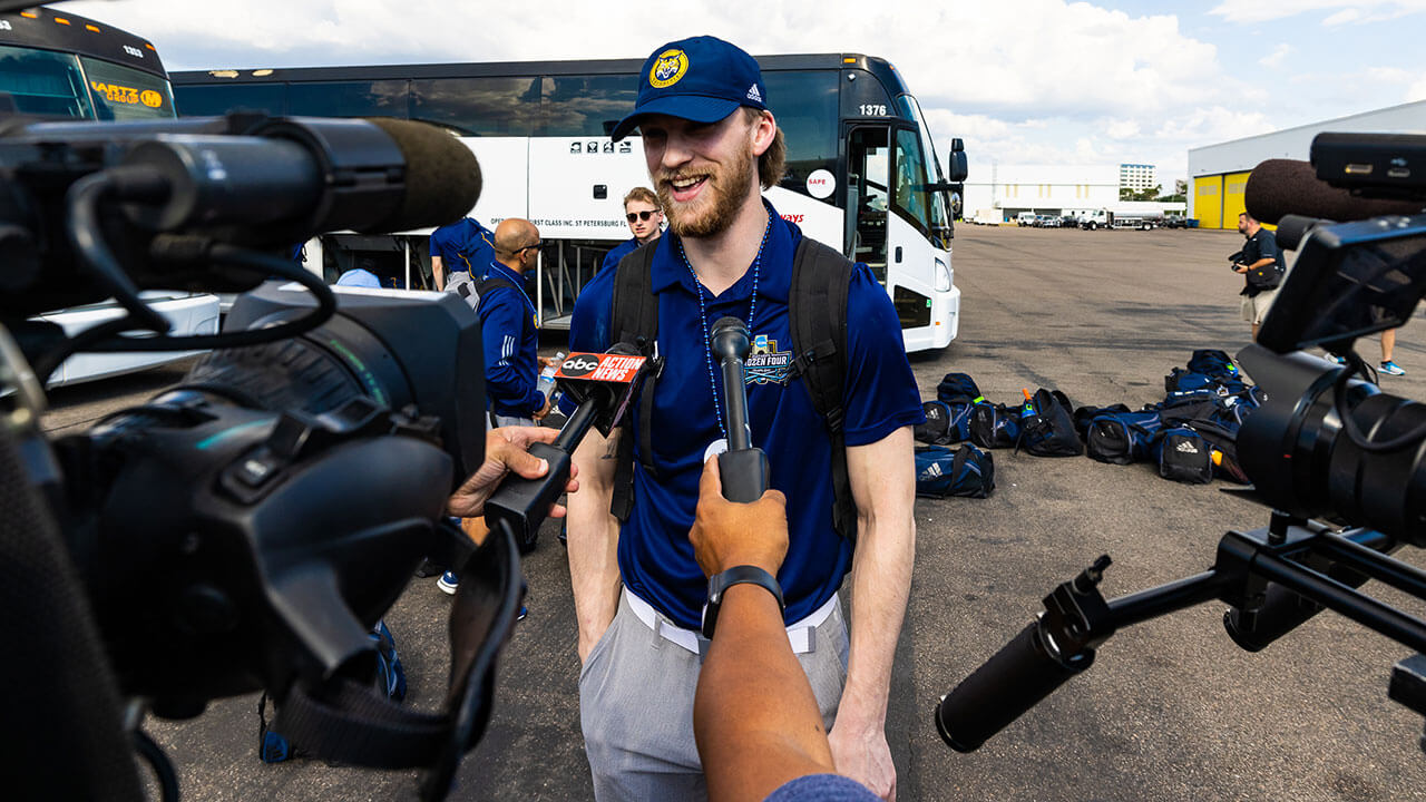 A member of the men's ice hockey team speaks with the media.