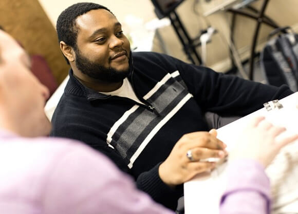 Burgess collaborates on a sheet of paper.