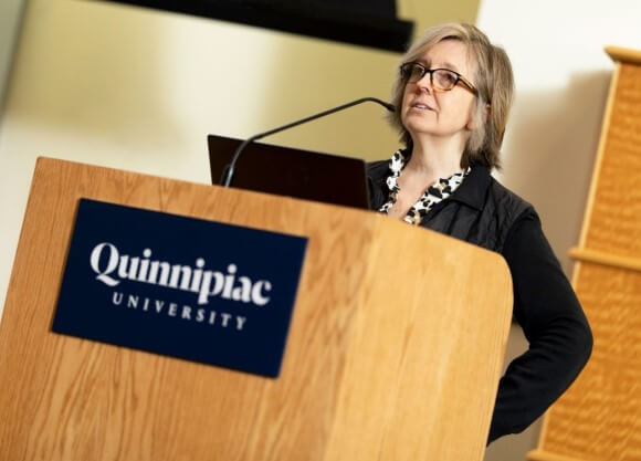 Selena Roberts stands at podium