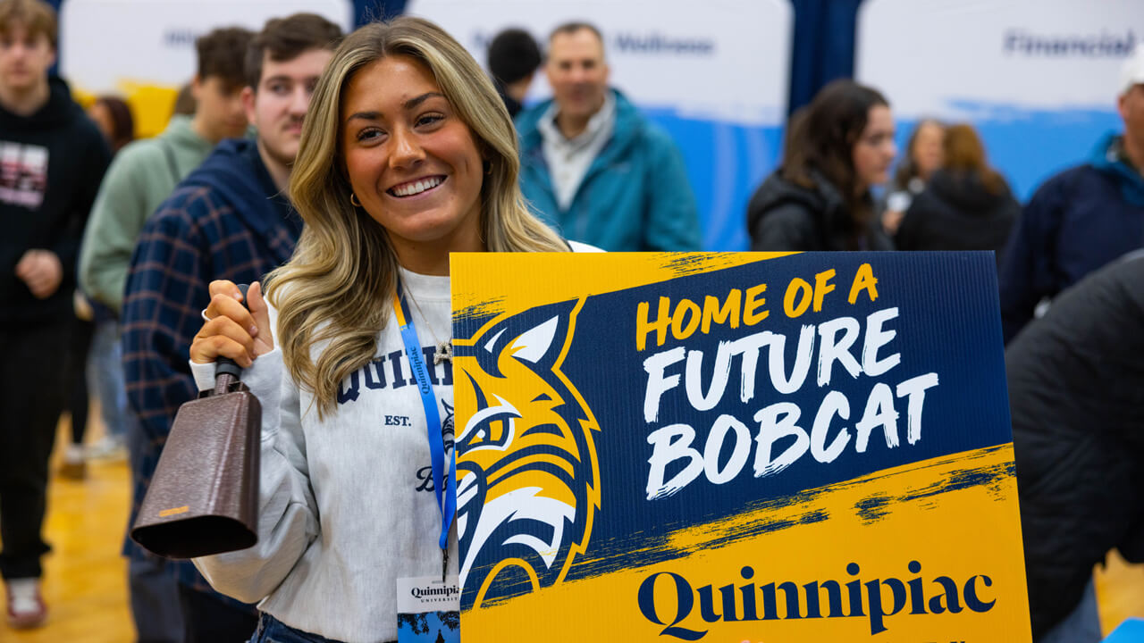 People pose for a photo holding a sign