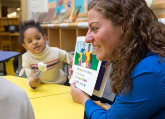 Student reads book to children