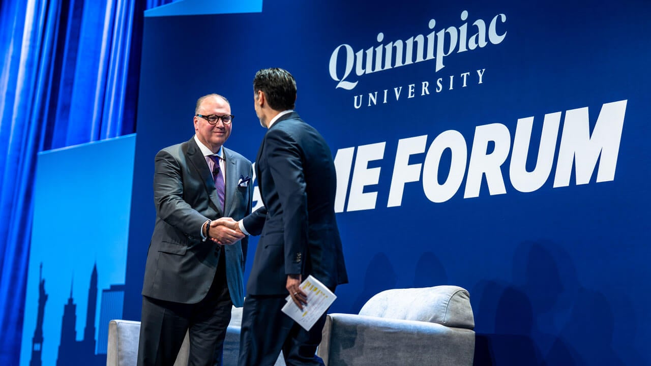 Two people hake hands on stage.