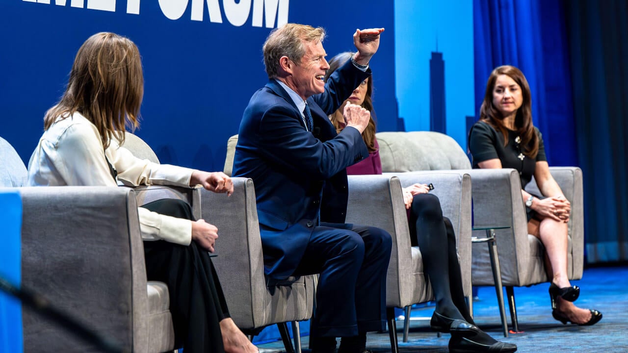 Panelists discuss with each other on stage.