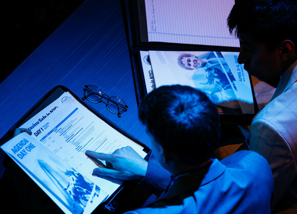 People looking at a book with numbers