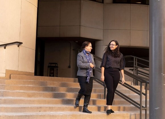 Kayla Stephen walks down the stairs with another woman at the New Haven court house.