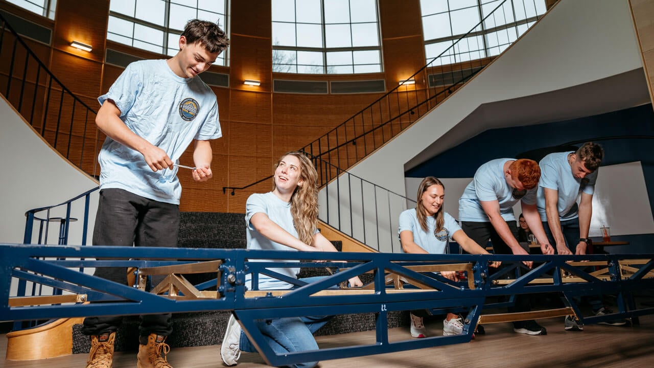 Students work collaboratively to build a steel bridge