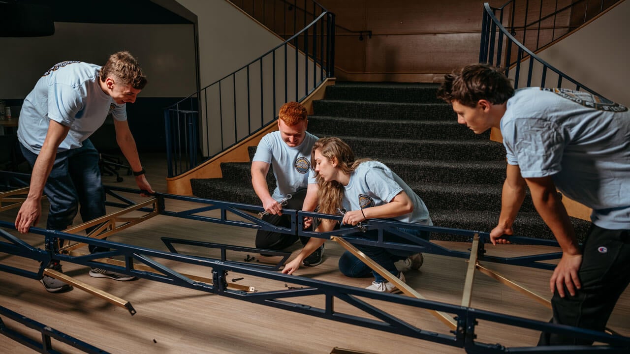 Students work collaboratively to build a bridge