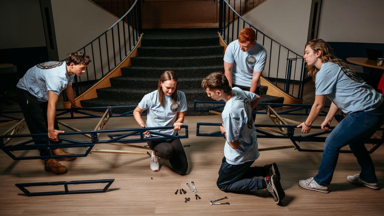 Students work collaboratively to build a steel bridge