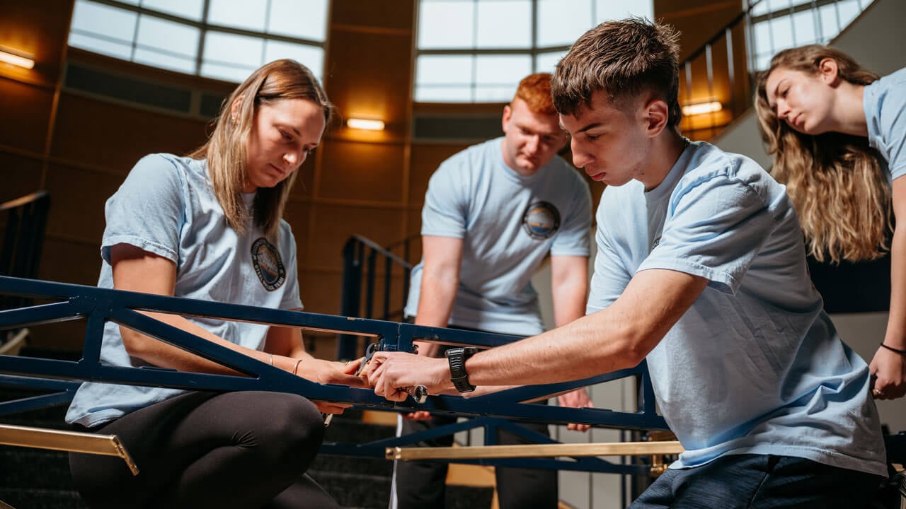 Students work collaboratively to build a bridge