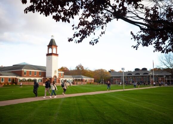 Dozens of students walk across the Quinnipiac quad in the autumn