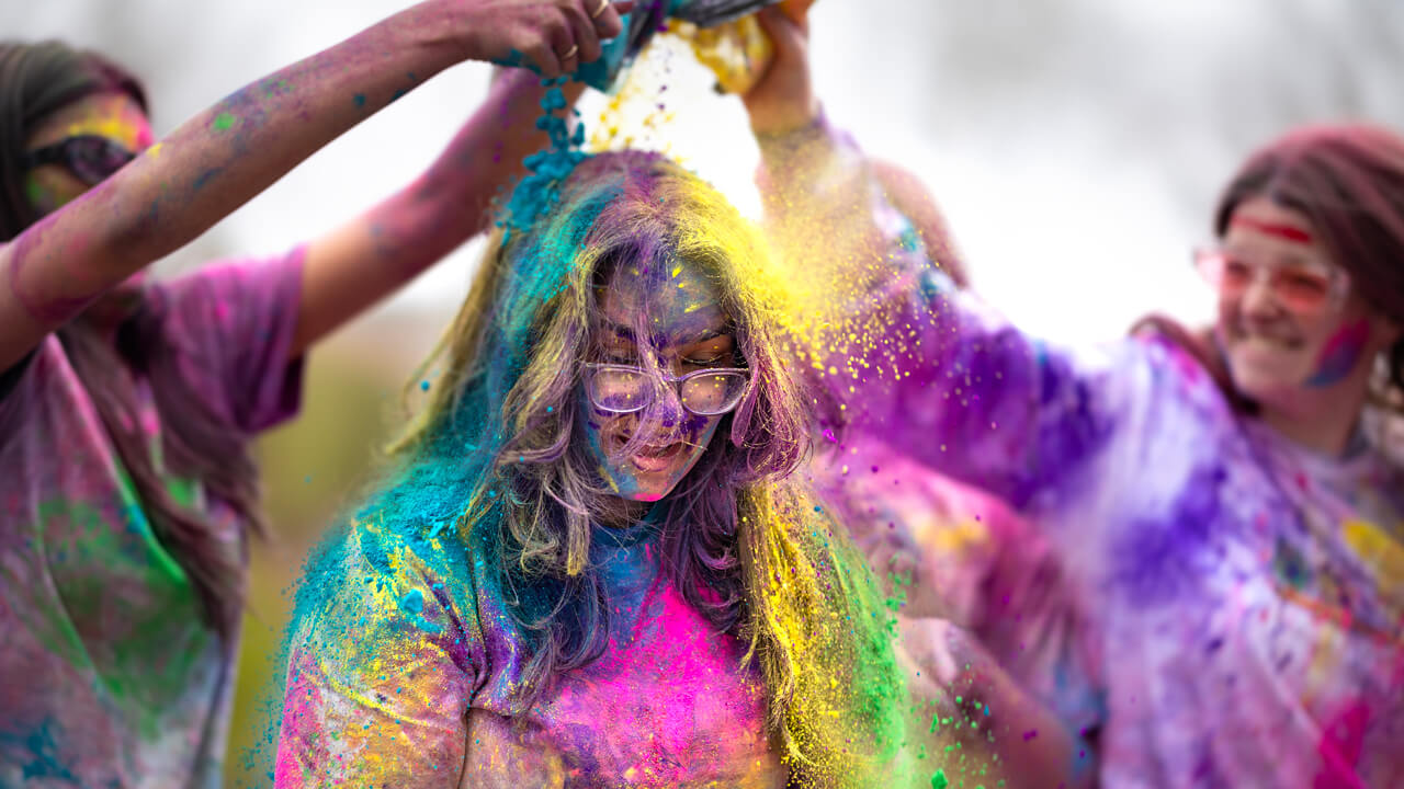 Individuals throwing colored power on each other