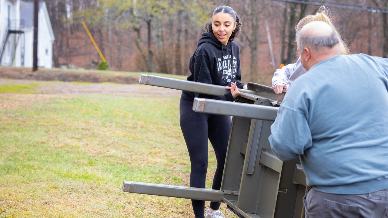 Individuals work together to lift a table