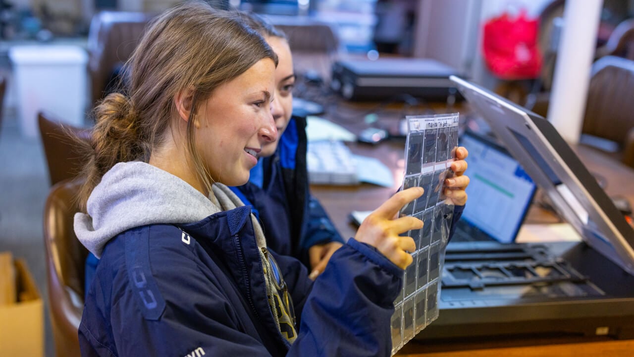 People looking at a sheet of photos