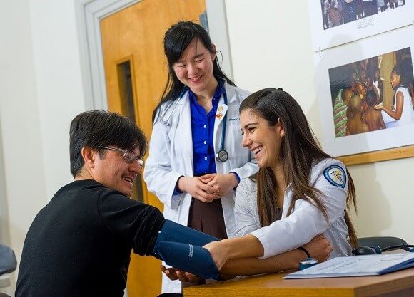 Quinnipiac Students Alexa Lee and Nicole Bahrami with Wazhinton Tello